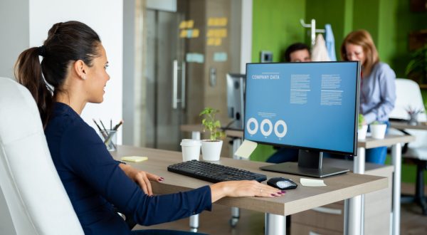 Businesswoman looks over the annual report figures in front of a computer
